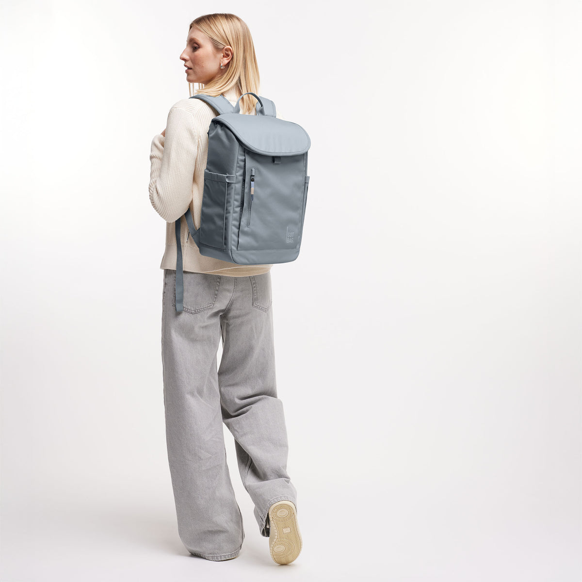 SERENE PACK Rucksack in marlin (grau-blau) von einer Frau als Rucksack auf dem Rücken getragen.