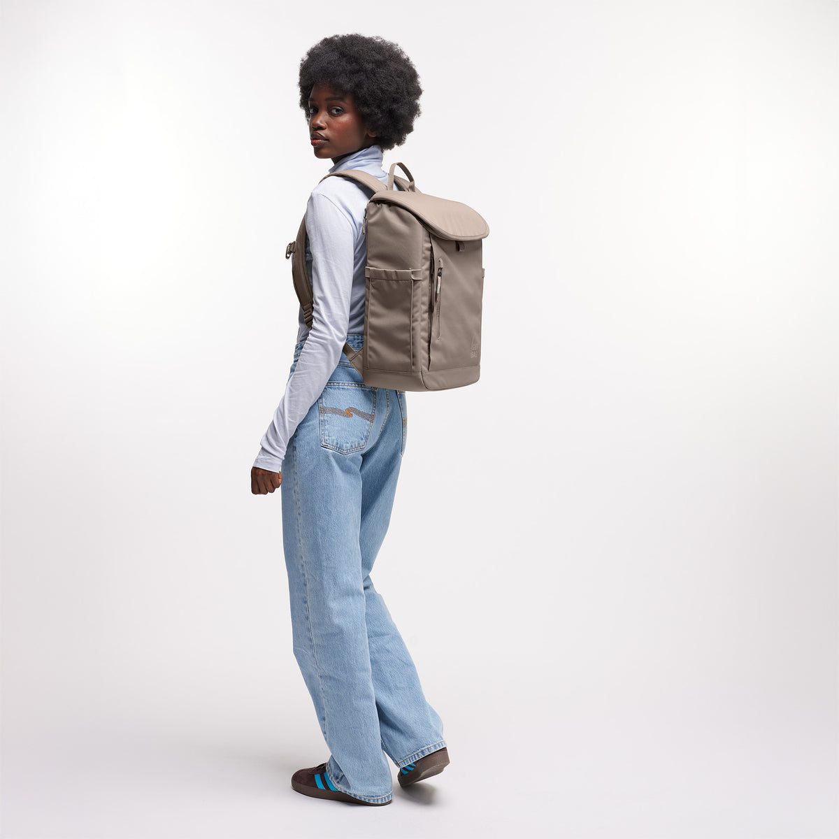 SERENE PACK Rucksack in oyster (klassisches Taupe-Braun) von einer Frau als Rucksack auf dem Rücken getragen.