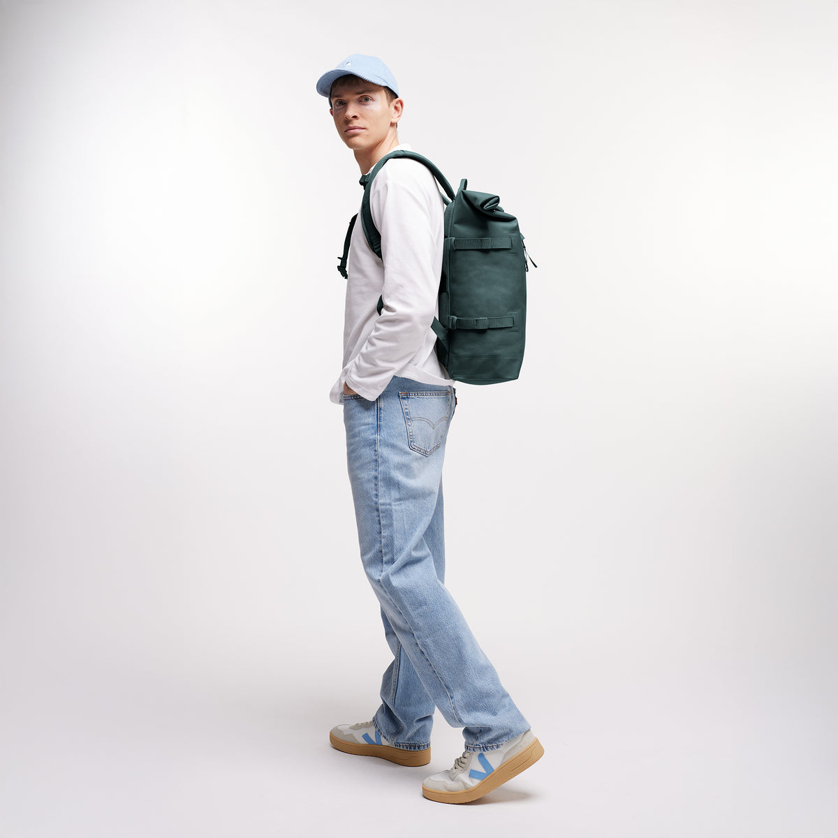 ROLLTOP Rucksack in sea teal (kühles Türkisgrün) von einem Mann als Rucksack auf dem Rücken getragen.