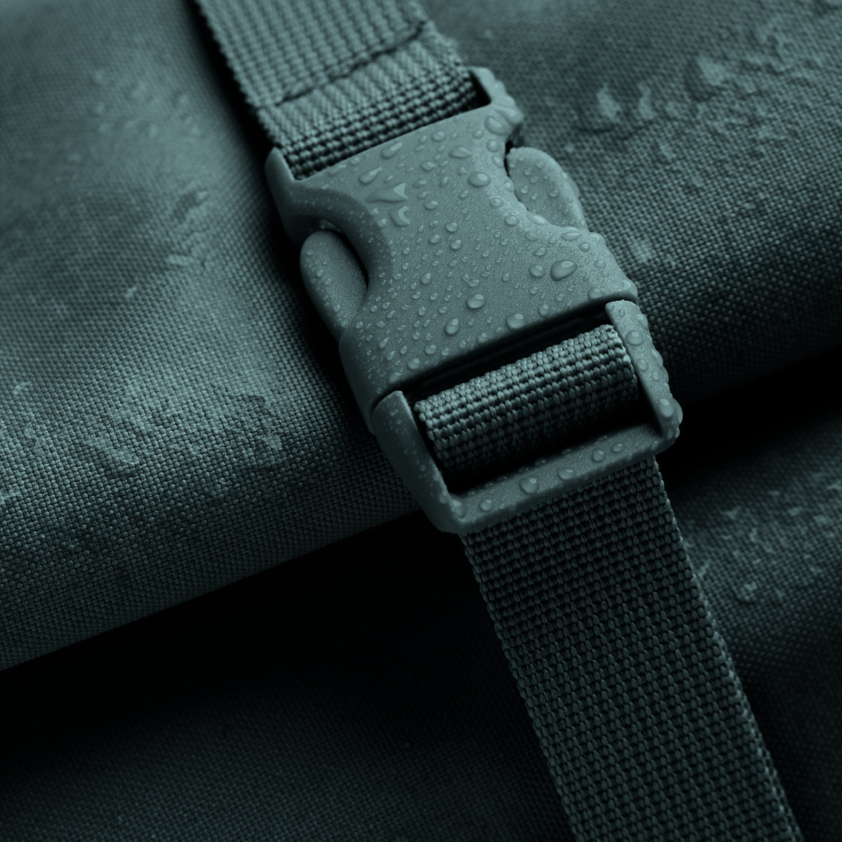 ROLLTOP 2.0 MONOCHROME EDITION Rucksack in sea teal (kühles Türkisgrün) als Detailaufnahme eines Verschlusses mit Wassertropfen.