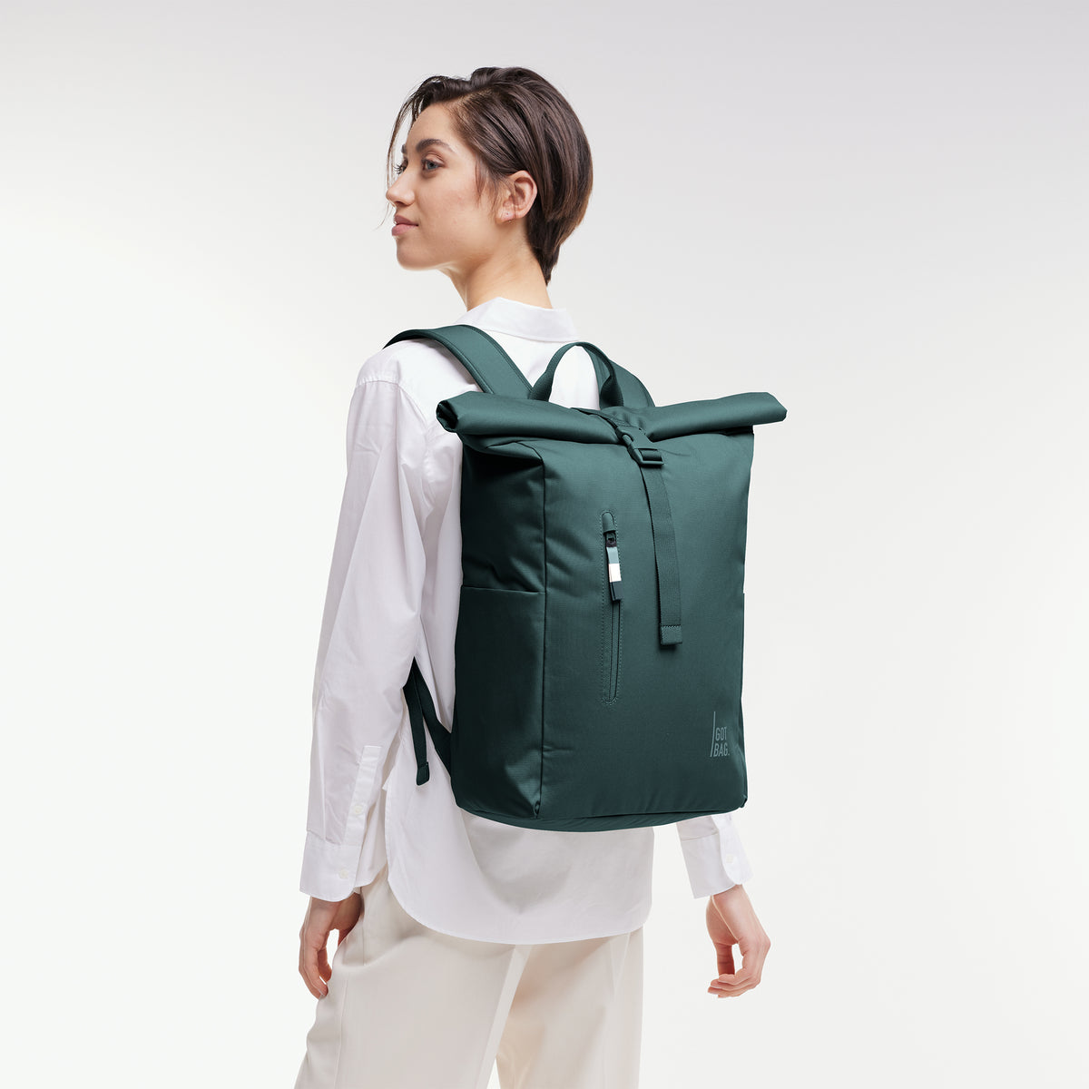 ROLLTOP EASY Rucksack in sea teal (kühles Türkisgrün) von einer Frau als Rucksack auf dem Rücken getragen.