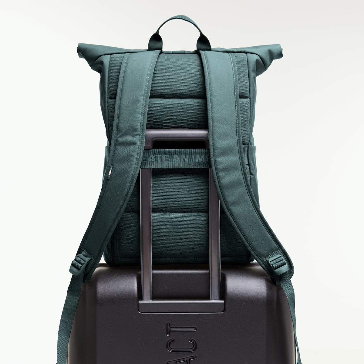 ROLLTOP EASY Rucksack in sea teal (kühles Türkisgrün), Rückansicht auf einem Koffer mit ausziehbarem Griff.
