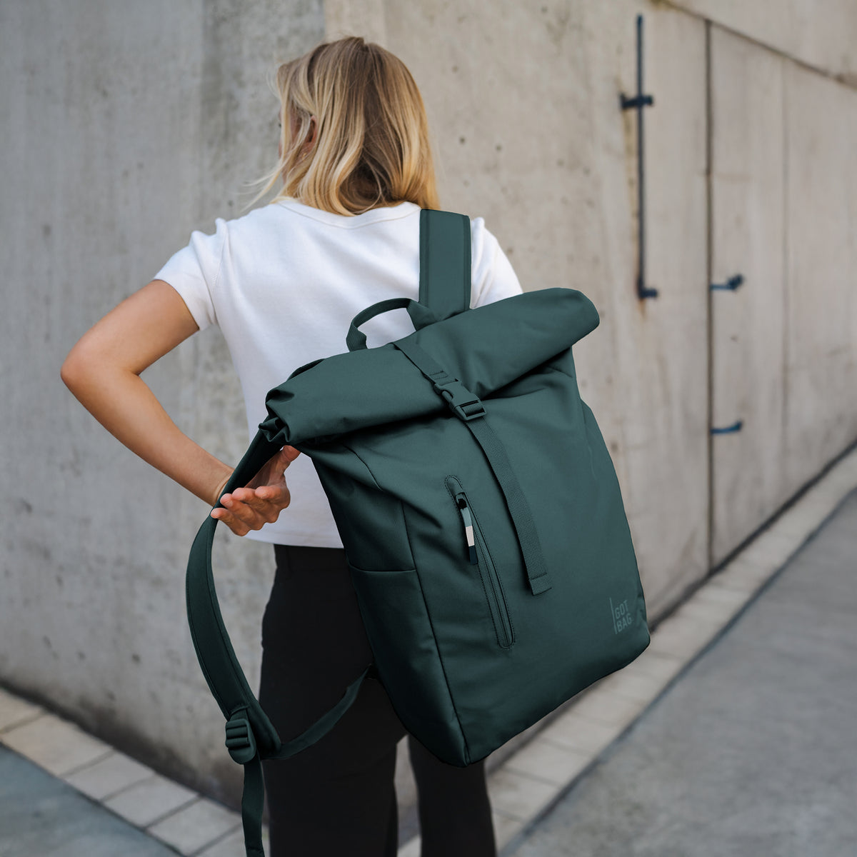 ROLLTOP EASY Rucksack in sea teal (kühles Türkisgrün) von einer Frau getragen.