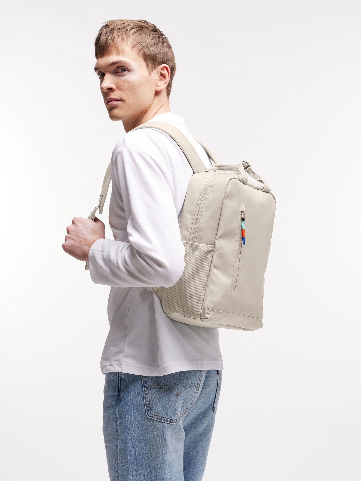 DAYPACK 2.0 Rucksack in soft shell (warmes Cremeweiß) von einem Mann auf dem Rücken getragen.