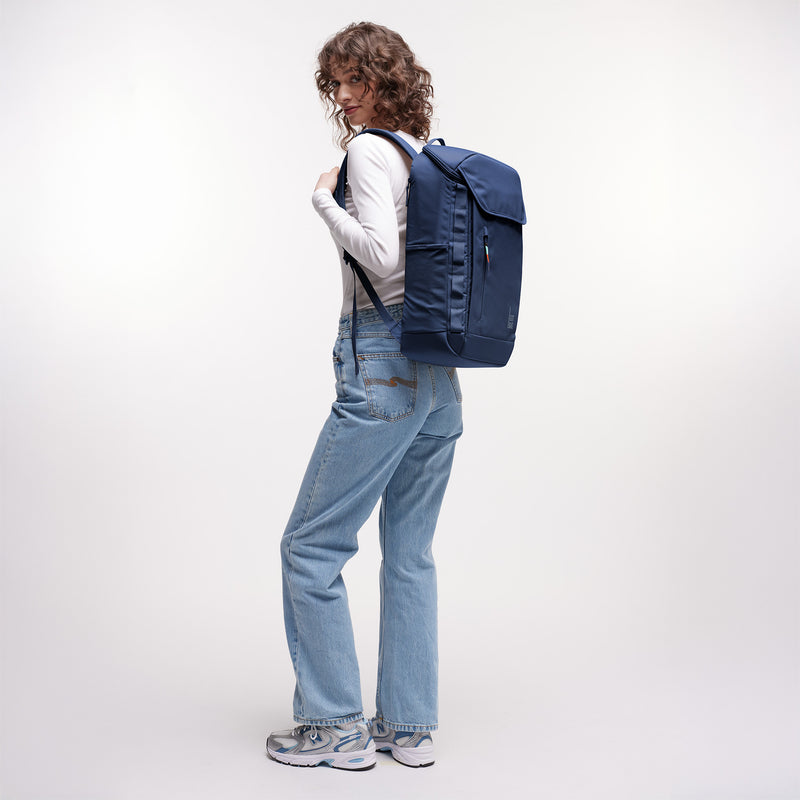 PRO PACK Rucksack in deep ocean (dunkles Marineblau) von einer Frau als Rucksack auf dem Rücken getragen.