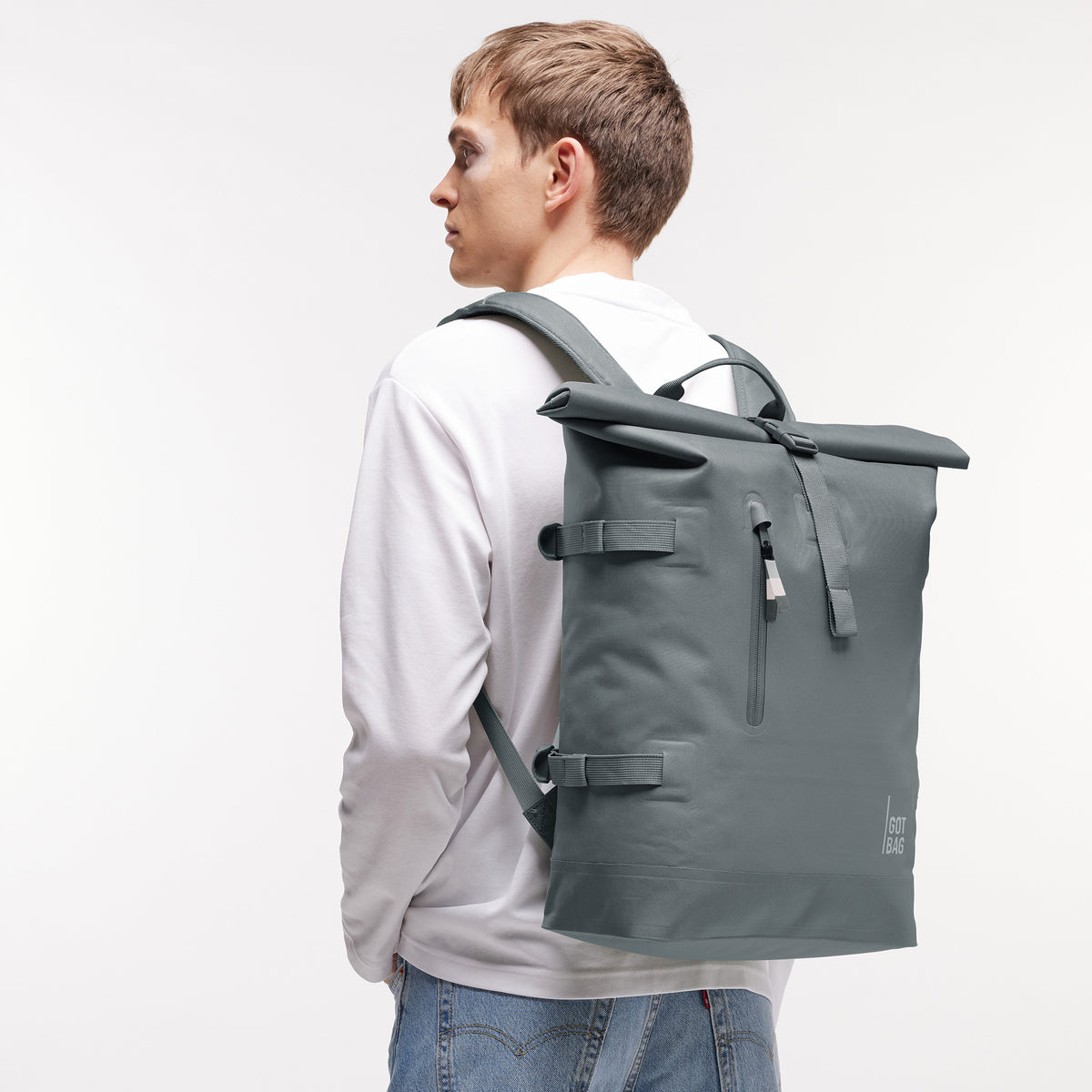 ROLLTOP 2.0 MONOCHROME EDITION Rucksack in basalt (graues Eisblau) von einem Mann auf dem Rücken getragen.