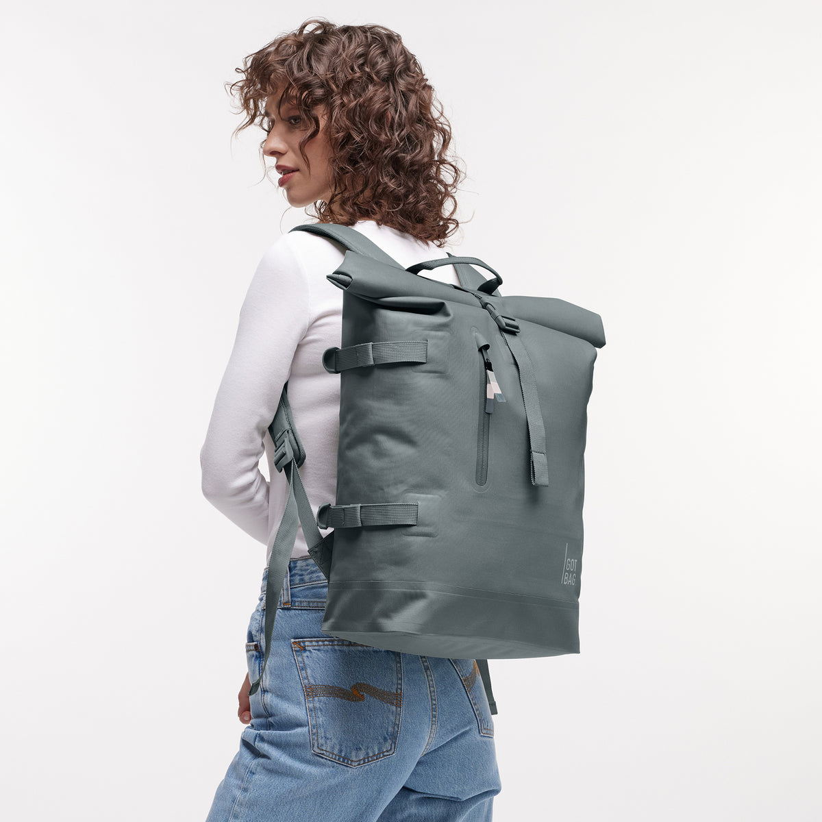ROLLTOP Rucksack in basalt (graues Eisblau) von einer Frau als Rucksack auf dem Rücken getragen.