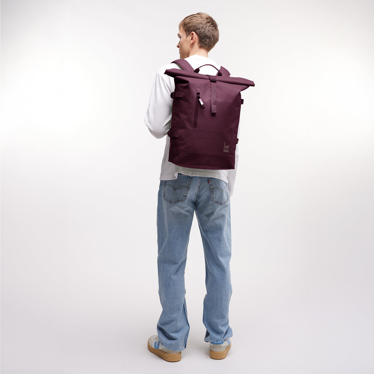 ROLLTOP Rucksack in kraken (Weinrot) von einem Mann als Rucksack auf dem Rücken getragen.