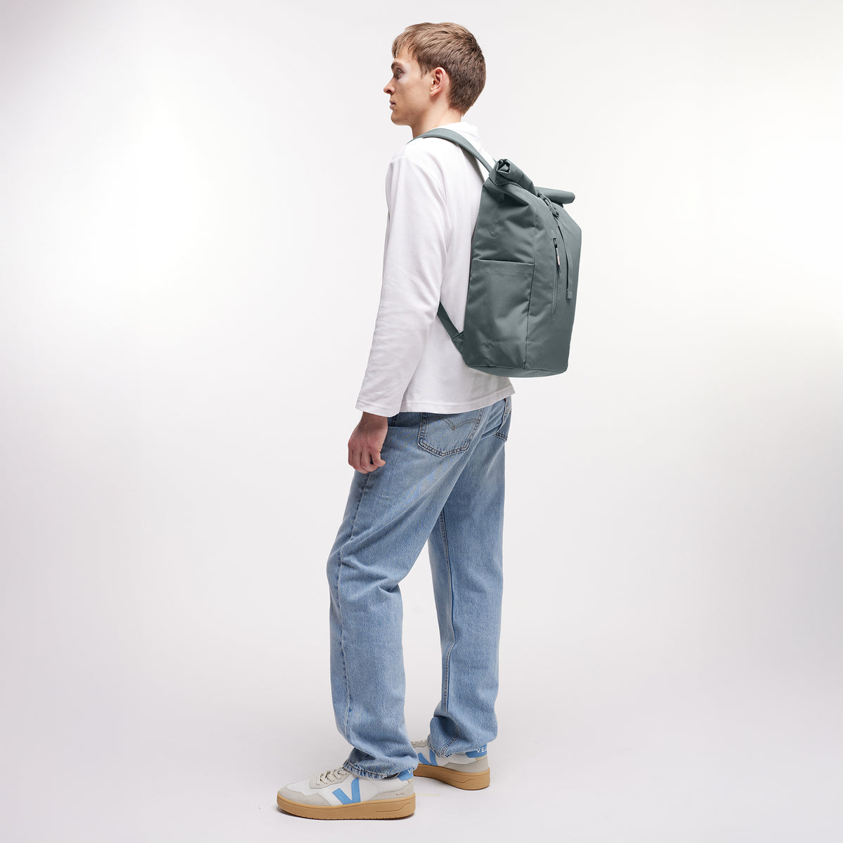 ROLLTOP EASY Rucksack in basalt (graues Eisblau) von einem Mann auf dem Rücken getragen.