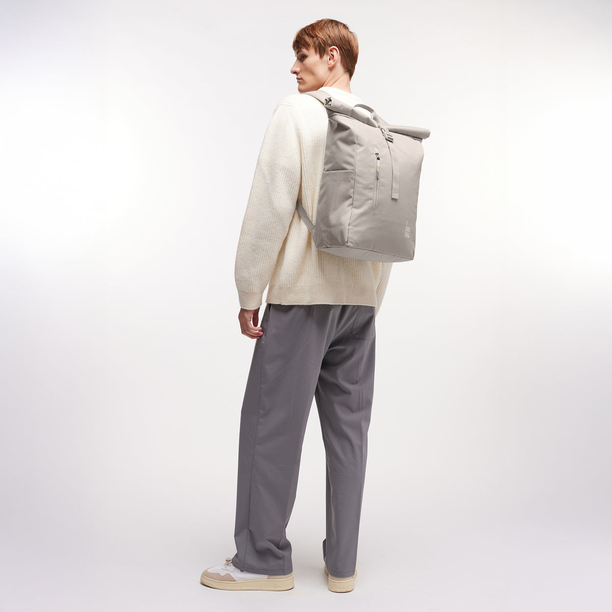 ROLLTOP EASY Rucksack in clam (helles, warmes Grau) von einem Mann als Rucksack auf dem Rücken getragen.