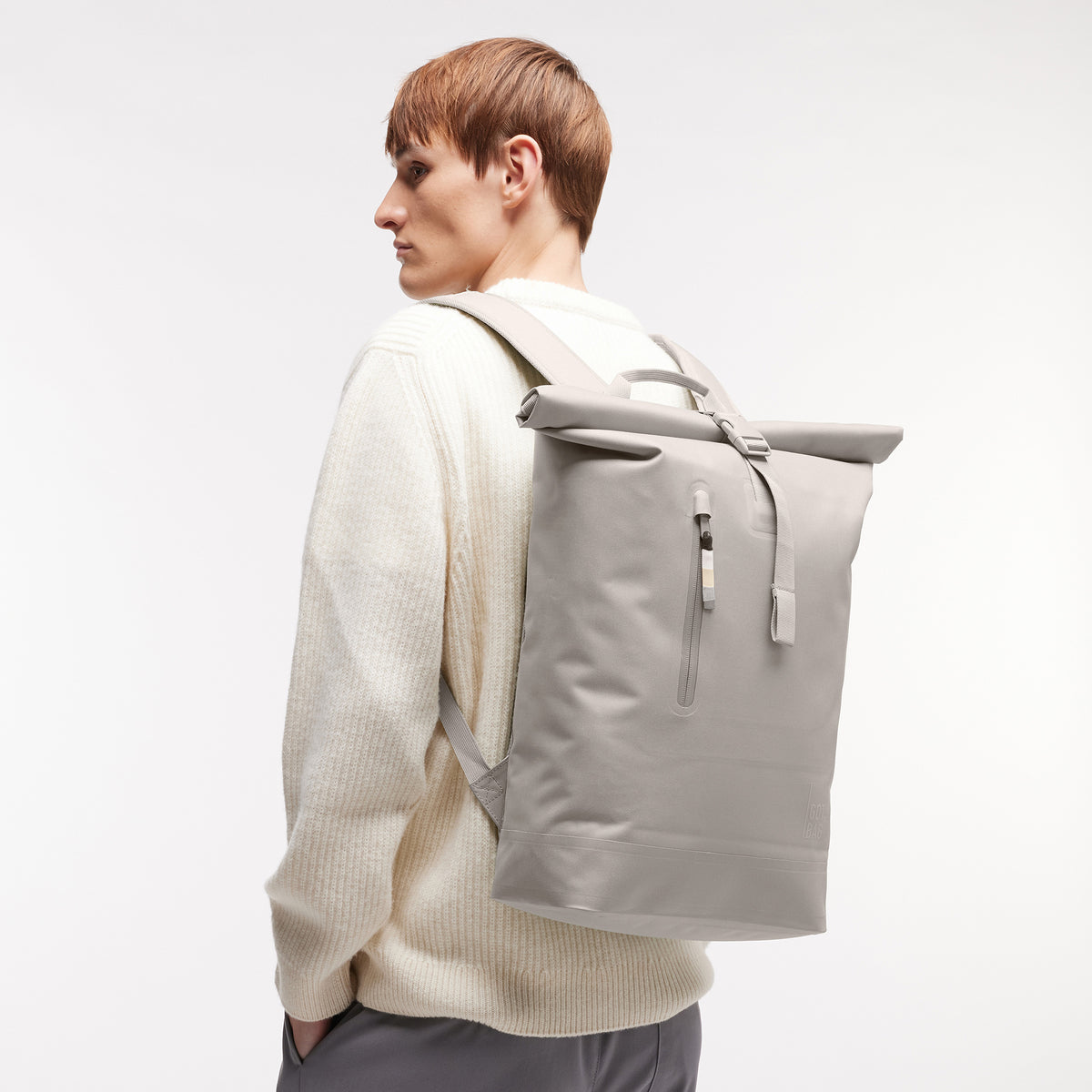 ROLLTOP LITE 2.0 MONOCHROME EDITION Rucksack in clam (helles, warmes Grau) von einem Mann auf dem Rücken getragen.
