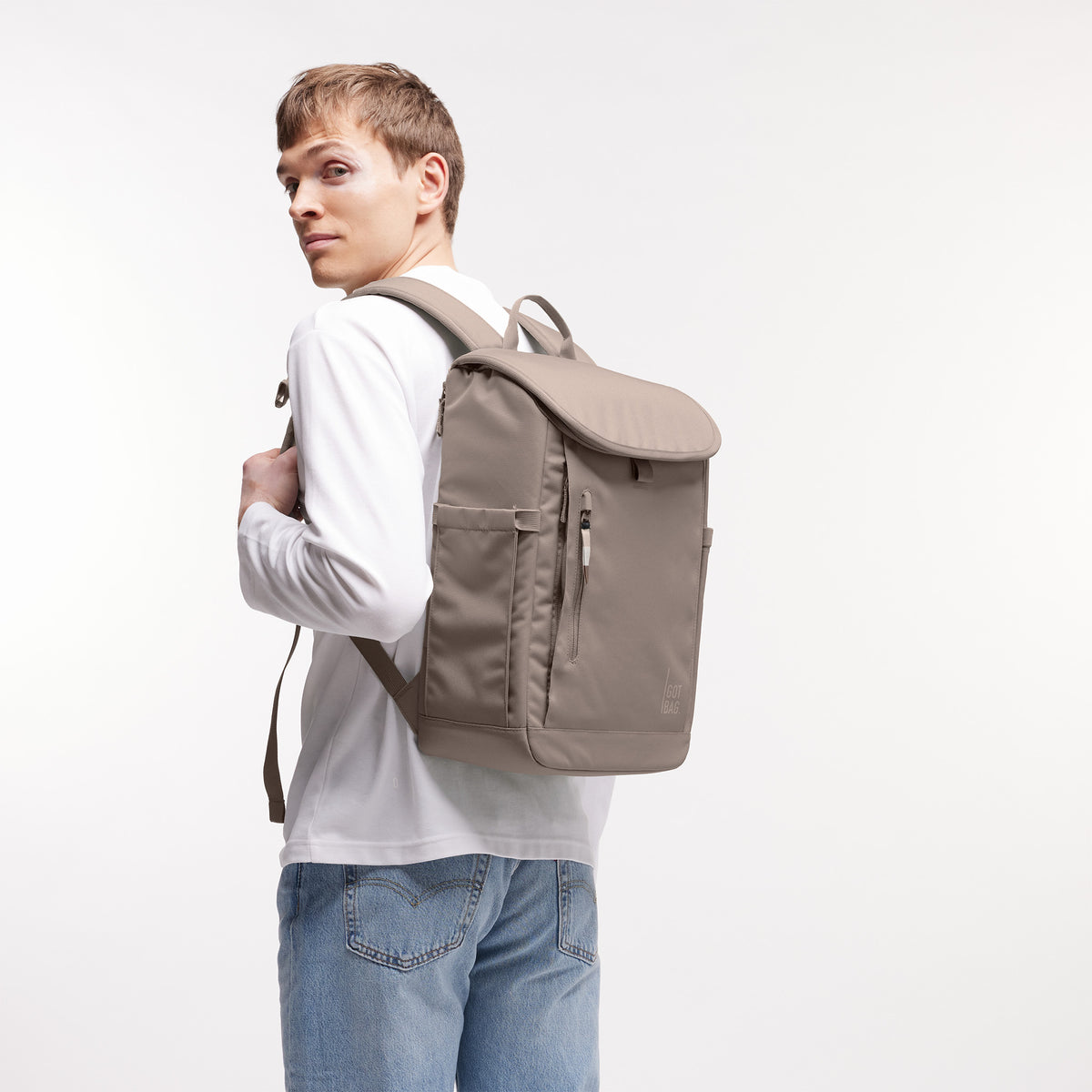 SERENE PACK Rucksack in oyster (klassisches Taupe-Braun) von einem Mann als Rucksack auf dem Rücken getragen.
