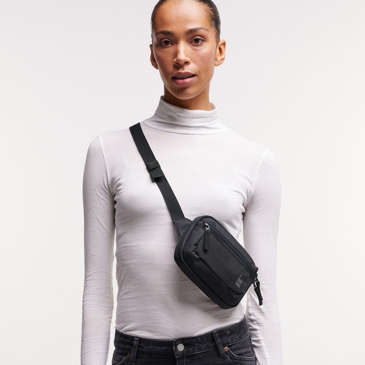 SLING BAG SMALL Tasche in black (Schwarz) von einer Frau crossbody getragen.
