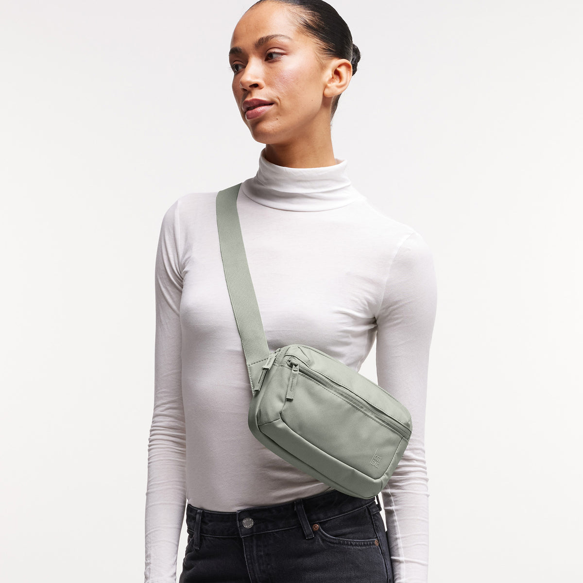 SLING BAG Tasche in bass (Salbeigrün) von einer Frau crossbody getragen.