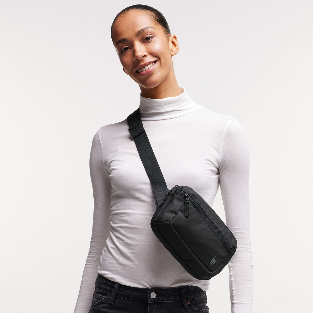 SLING BAG Tasche in black (Schwarz) von einer Frau crossbody getragen.