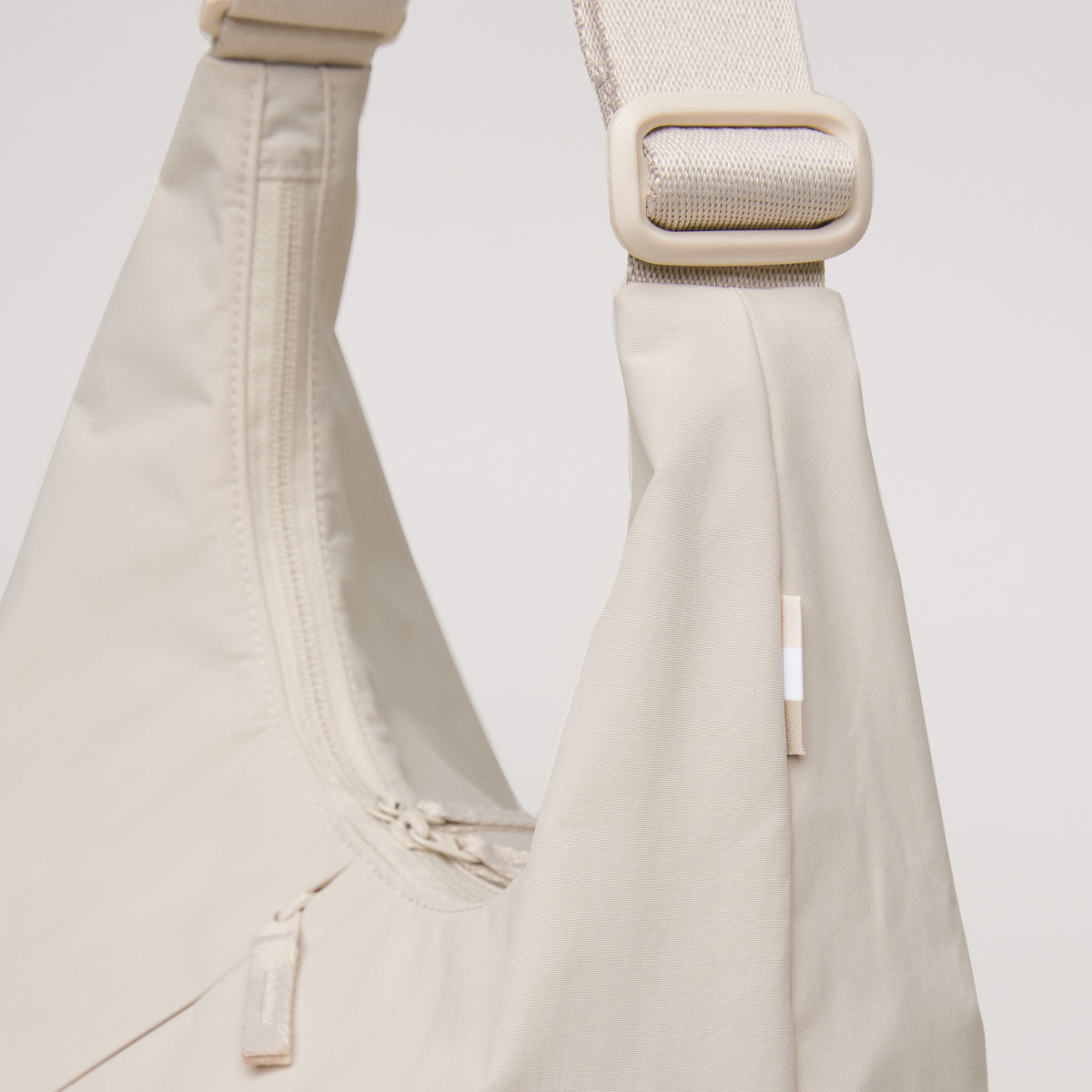 T SHAPE BAG LARGE Tasche in soft shell (warmes Cremeweiß) als Detailaufnahme.