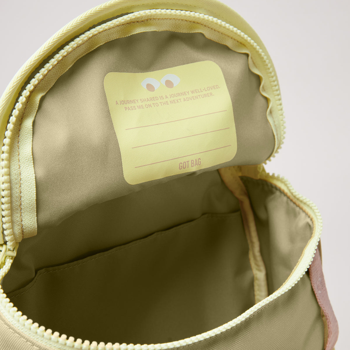 KIDS ADVENTURE DAYPACK Rucksack in nori (pastellfarbenes Pistaziengrün), Detailaufnahme des Innenraums mit Label.