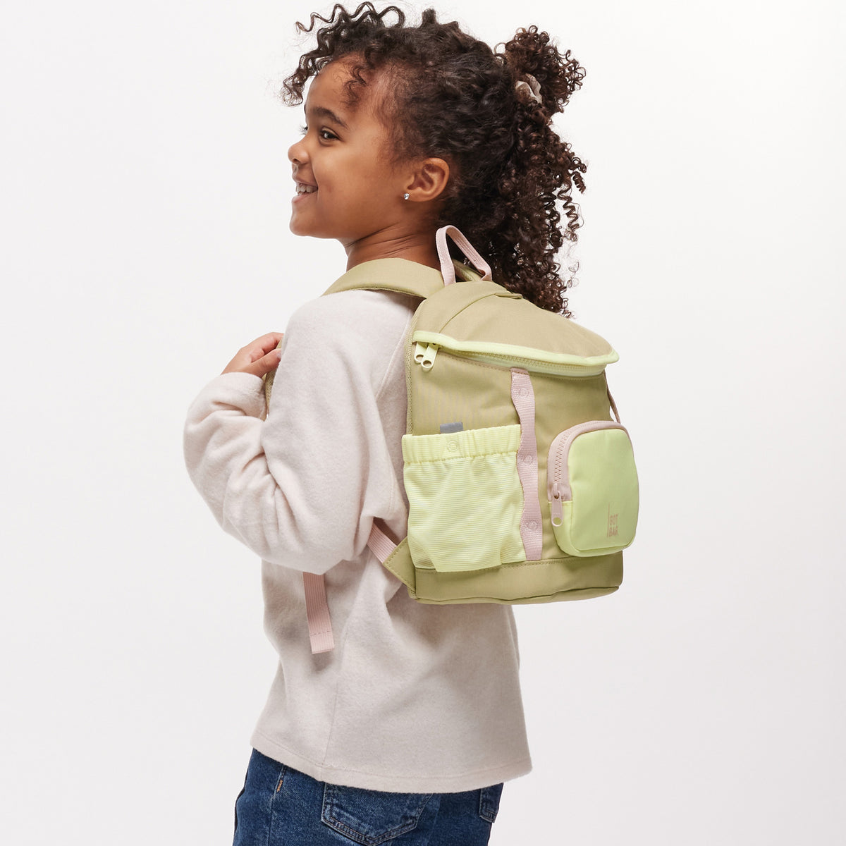 KIDS ADVENTURE DAYPACK Rucksack in nori (pastellfarbenes Pistaziengrün) von einem Kind auf dem Rücken getragen.