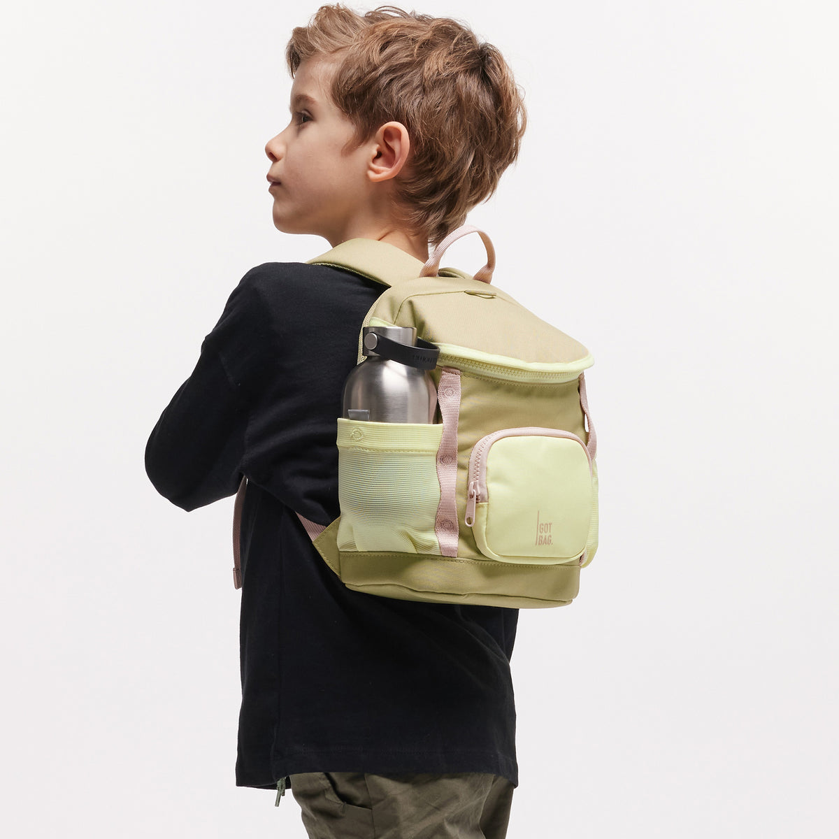 KIDS ADVENTURE DAYPACK Rucksack in nori (pastellfarbenes Pistaziengrün) von einem Kind auf dem Rücken getragen.