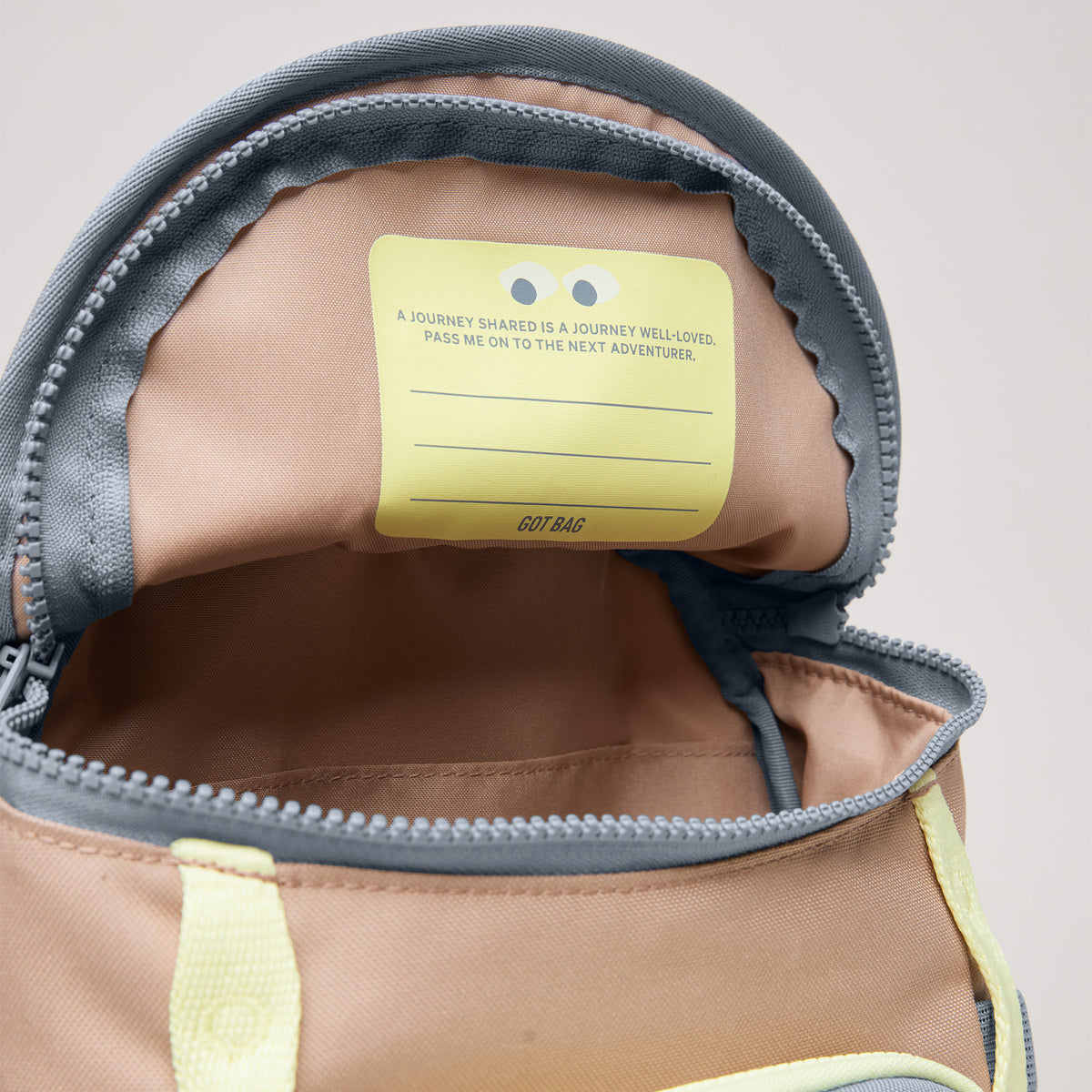 KIDS ADVENTURE DAYPACK Rucksack in sandbar (warmes Beige mit rötlichem Unterton), offene Innenansicht mit Label.