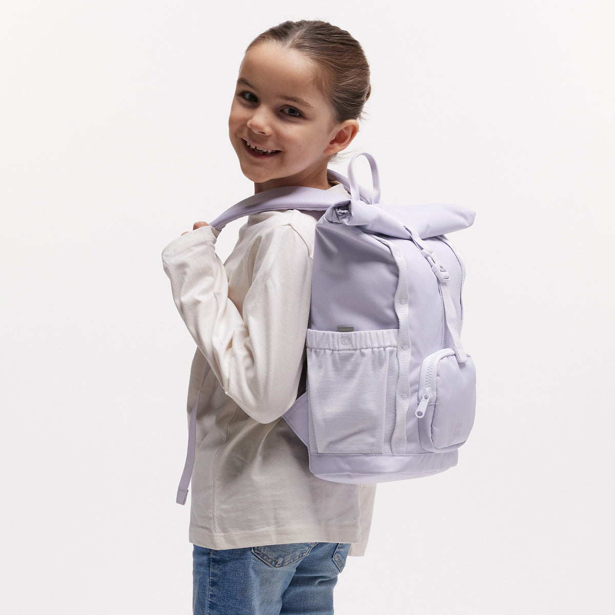 KIDS ADVENTURE ROLLTOP Rucksack in purple coral (pastellfarbenes helles Flieder) von einer Frau auf dem Rücken getragen.