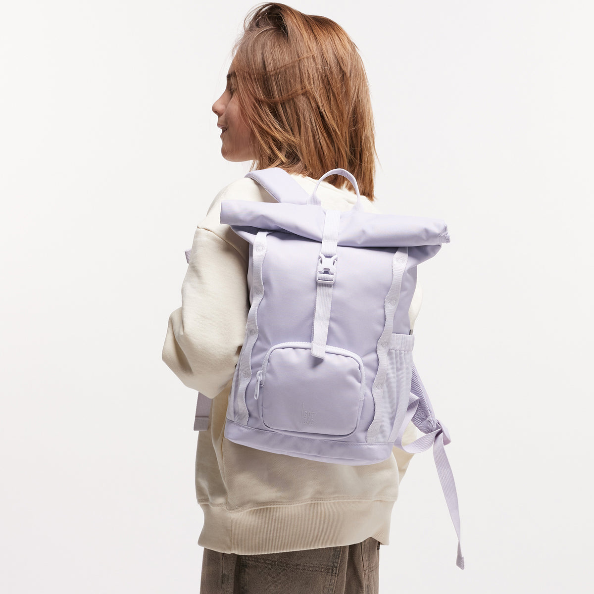 KIDS ADVENTURE ROLLTOP Rucksack in purple coral (pastellfarbenes helles Flieder) von einem Kind auf dem Rücken getragen.