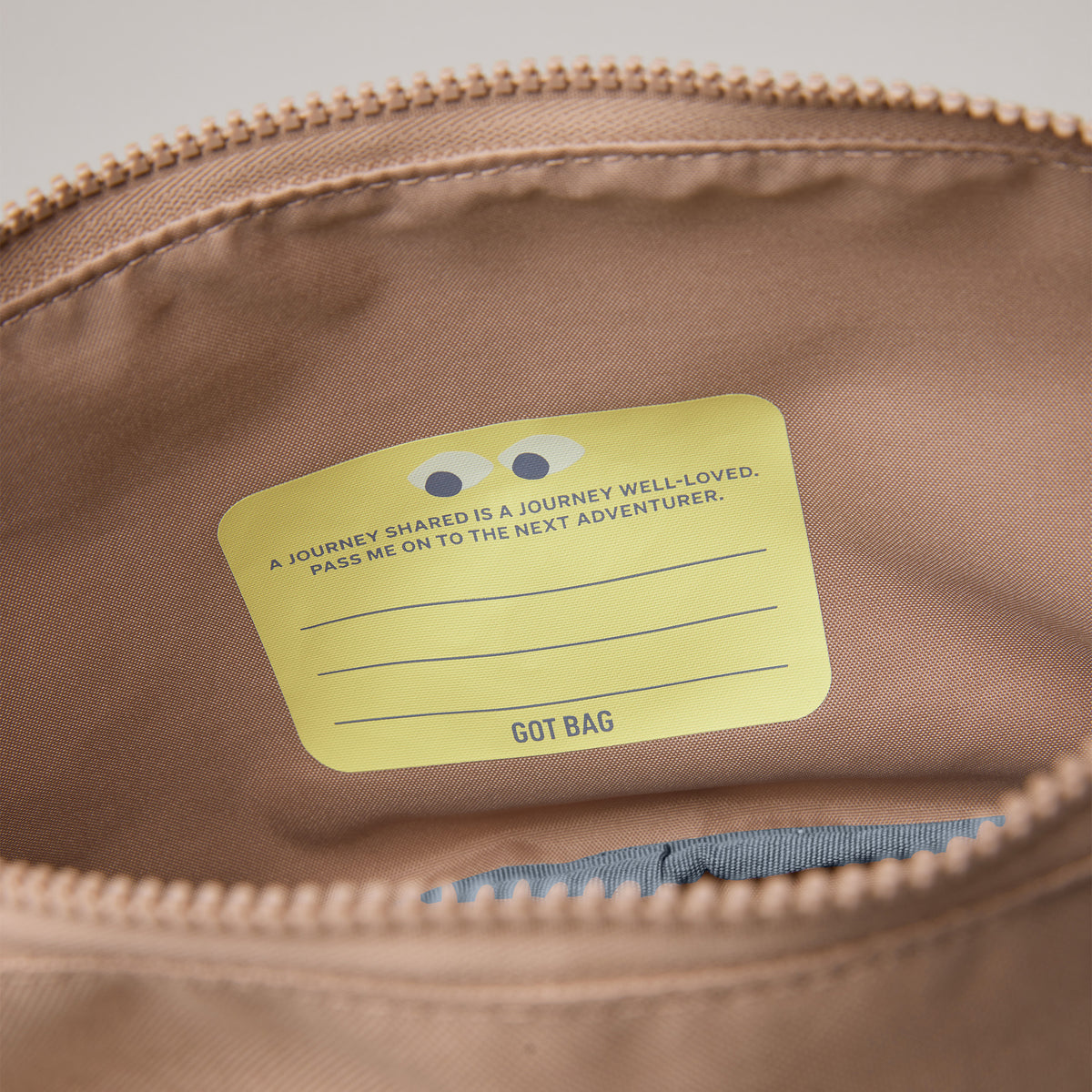 KIDS ADVENTURE ROLLTOP Rucksack in sandbar (warmes Beige mit rötlichem Unterton) Detailaufnahme des Innenbereichs mit gelbem Etikett.