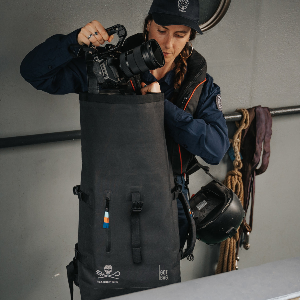 ROLLTOP 2.0 Rucksack in black (Schwarz) wird von einer Frau befüllt.