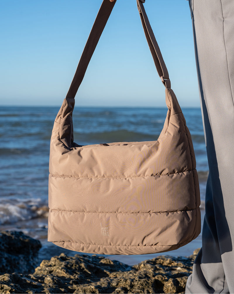 PUFFER SQUARE BAG LARGE tas in oyster (Klassiek taupe-bruin) over de schouder gedragen.