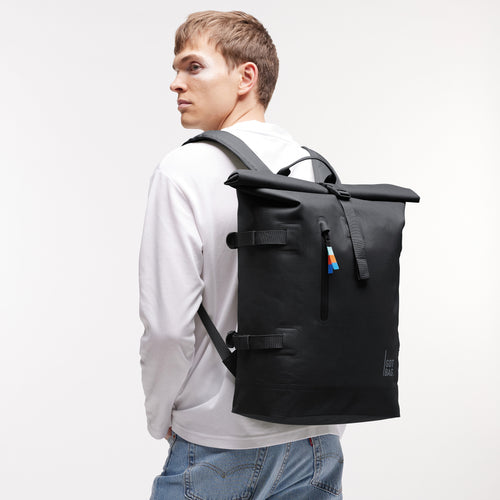 ROLLTOP 2.0 Rucksack in black (Schwarz) von einem Mann als Rucksack auf dem Rücken getragen.