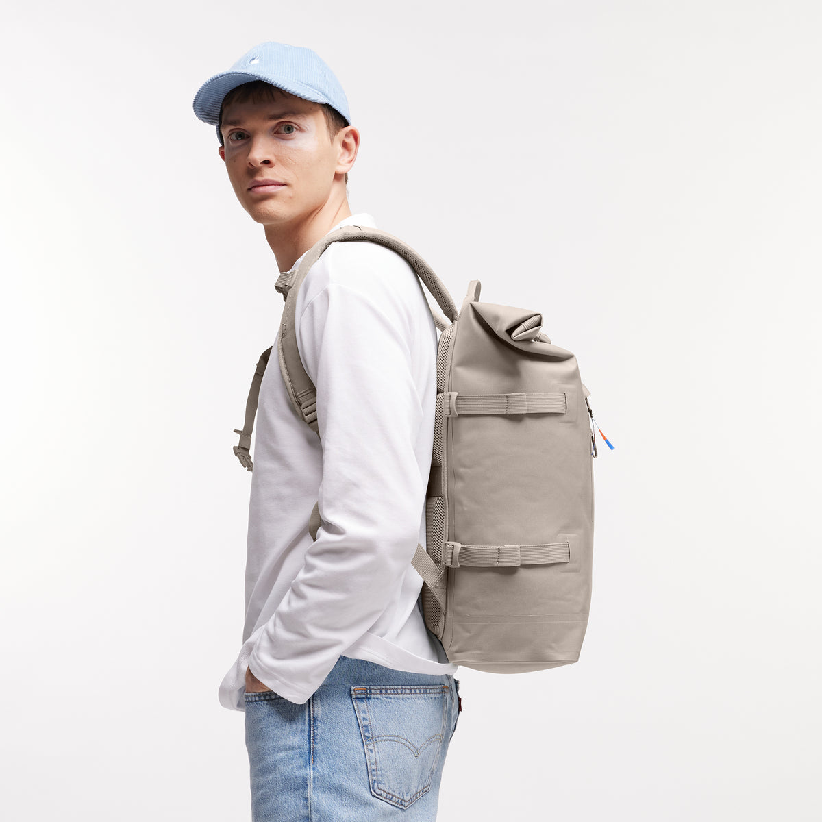 ROLLTOP Rucksack in scallop (helles Beige) von einem Mann auf dem Rücken getragen.