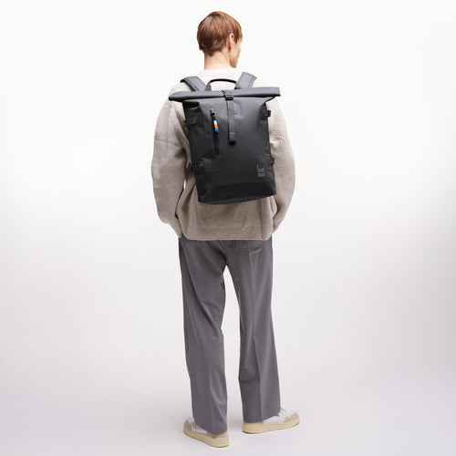 ROLLTOP Rucksack in shark (Dunkelgrau) von einem Mann als Rucksack auf dem Rücken getragen.