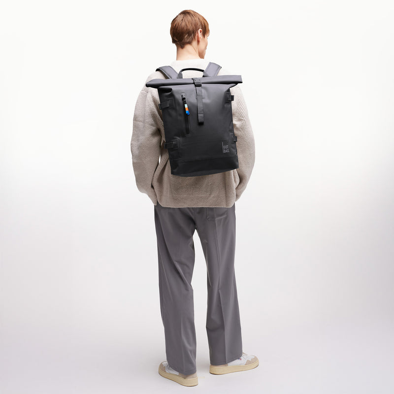 ROLLTOP Rucksack in shark (Dunkelgrau) von einem Mann als Rucksack auf dem Rücken getragen.