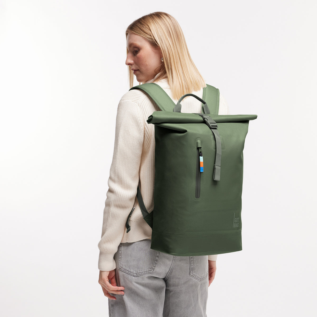 ROLLTOP LITE Rucksack in algae (Dunkelgrün mit Graustich) von einer Frau auf dem Rücken getragen.