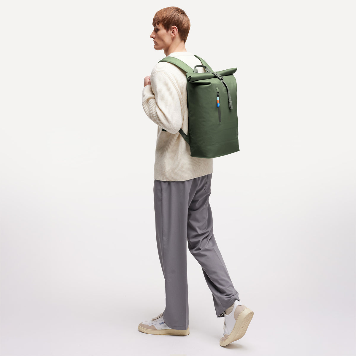 ROLLTOP LITE Rucksack in algae (Dunkelgrün mit Graustich) von einem Mann auf dem Rücken getragen.