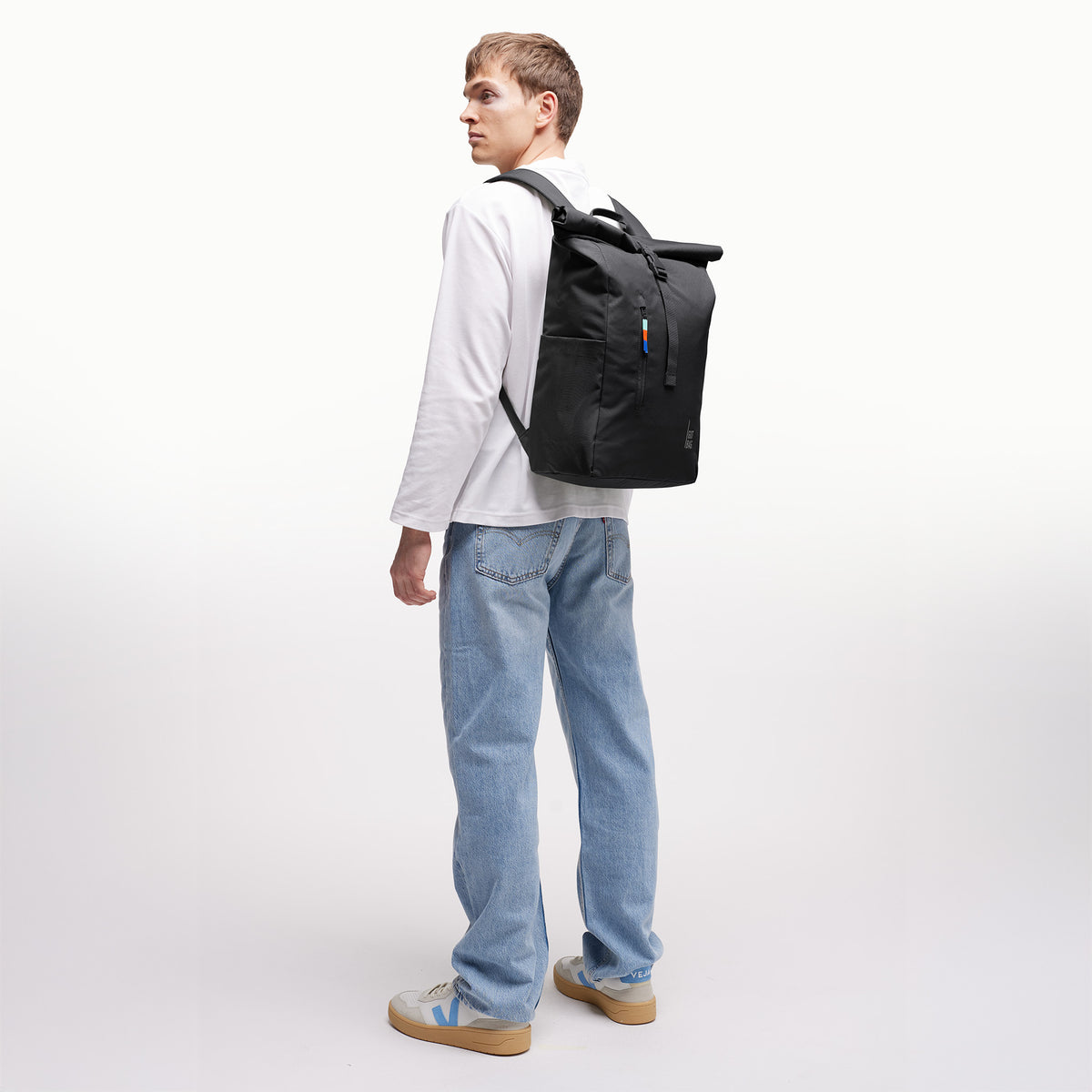 ROLLTOP EASY Rucksack in black (Schwarz) von einem Mann als Rucksack auf dem Rücken getragen.