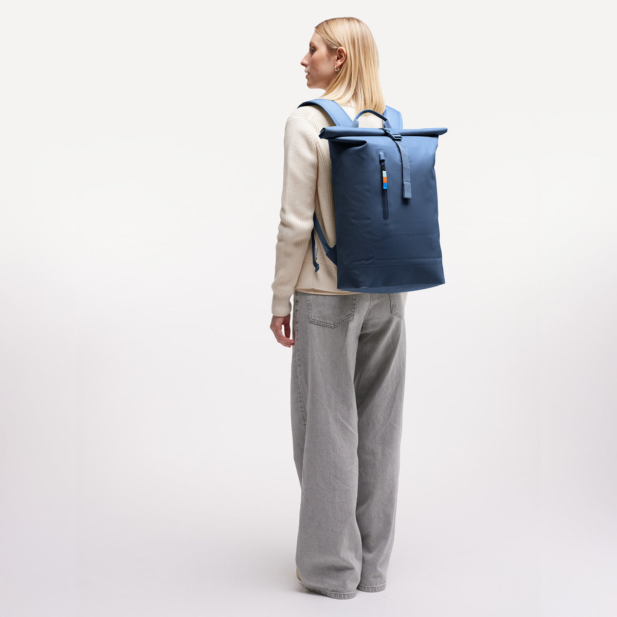 ROLLTOP LITE Rucksack in ocean von einer Frau auf dem Rücken getragen.