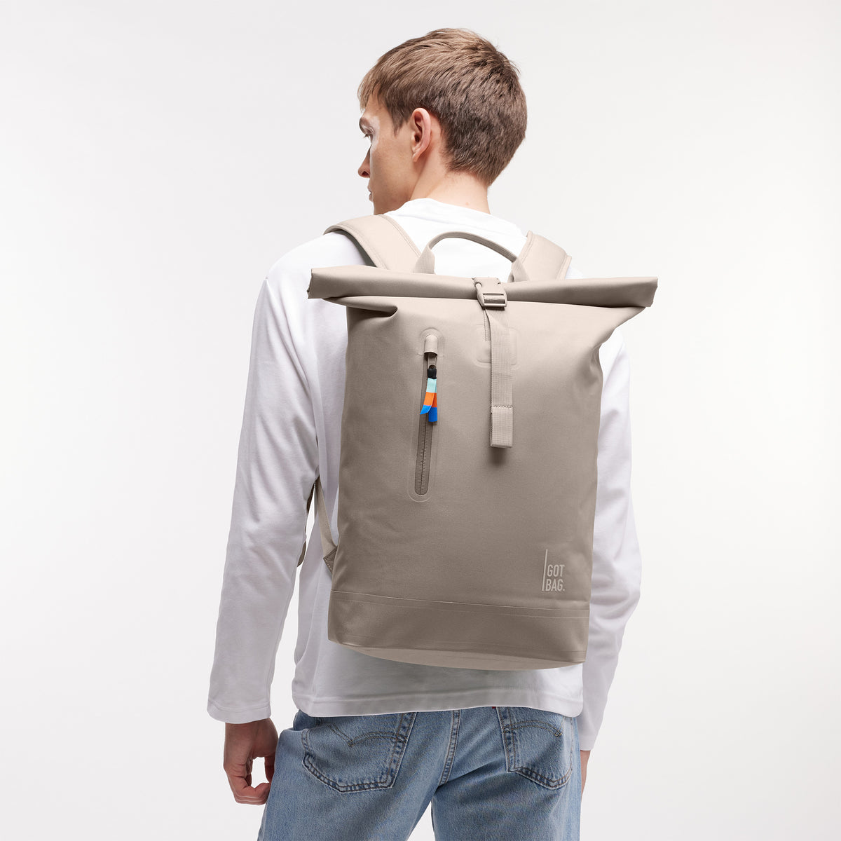ROLLTOP LITE Rucksack in scallop (helles Beige) von einem Mann auf dem Rücken getragen.