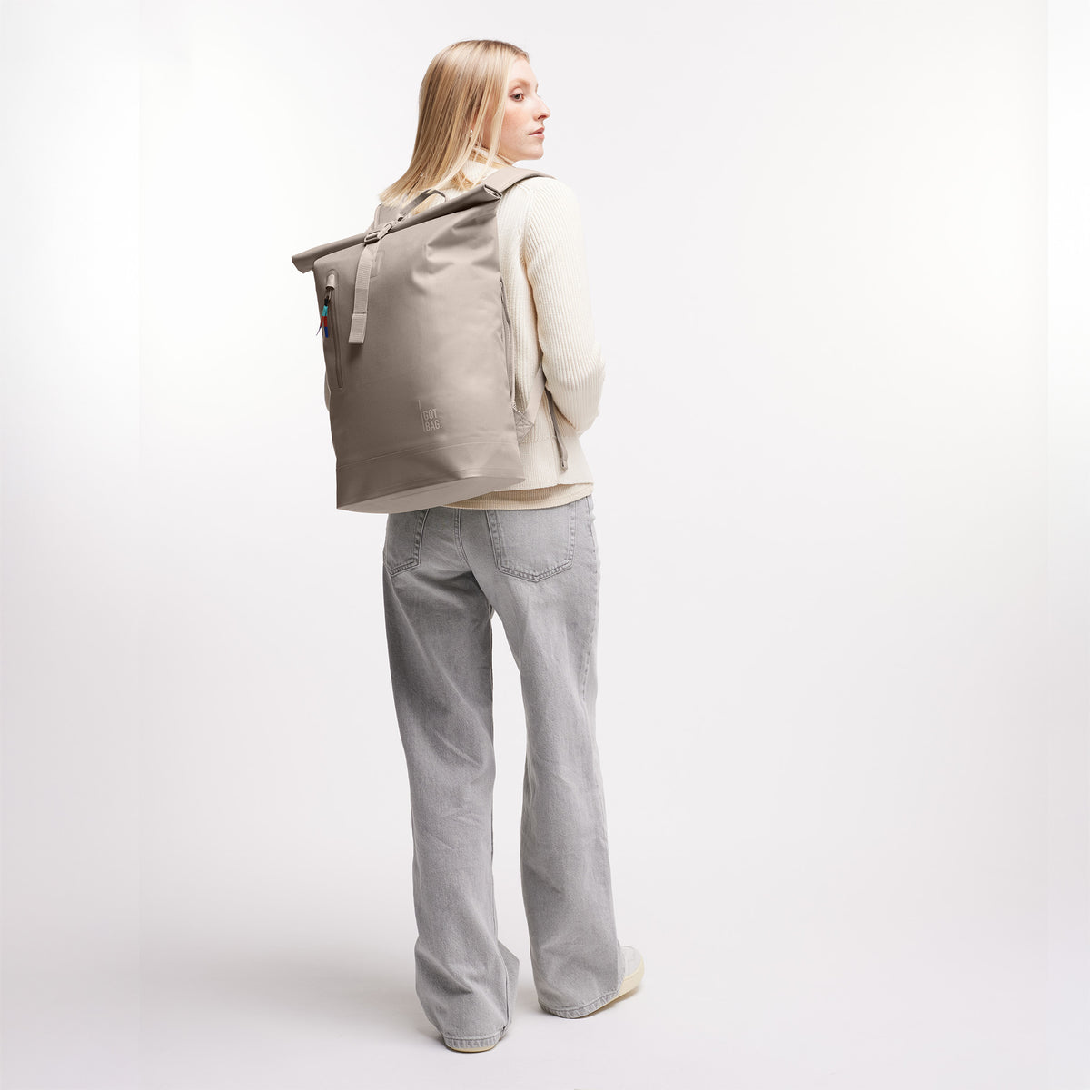 ROLLTOP LITE Rucksack in scallop (helles Beige) von einer Frau als Rucksack auf dem Rücken getragen.