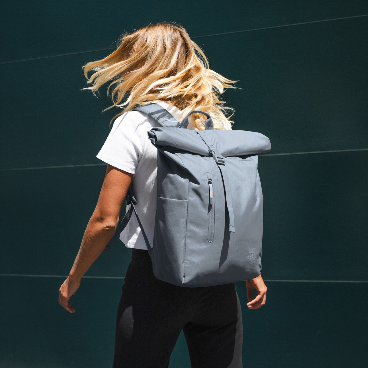 ROLLTOP EASY Rucksack in marlin (grau-blau) von einer Frau auf dem Rücken getragen.
