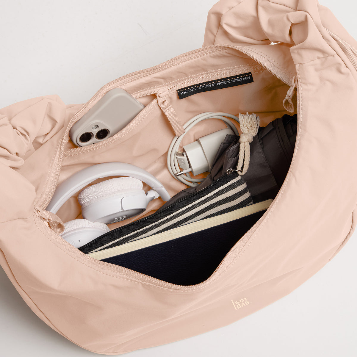 MOON BAG RUFFLE Tasche in pearl (helles Puder-Rosa), offen mit Inhalt.