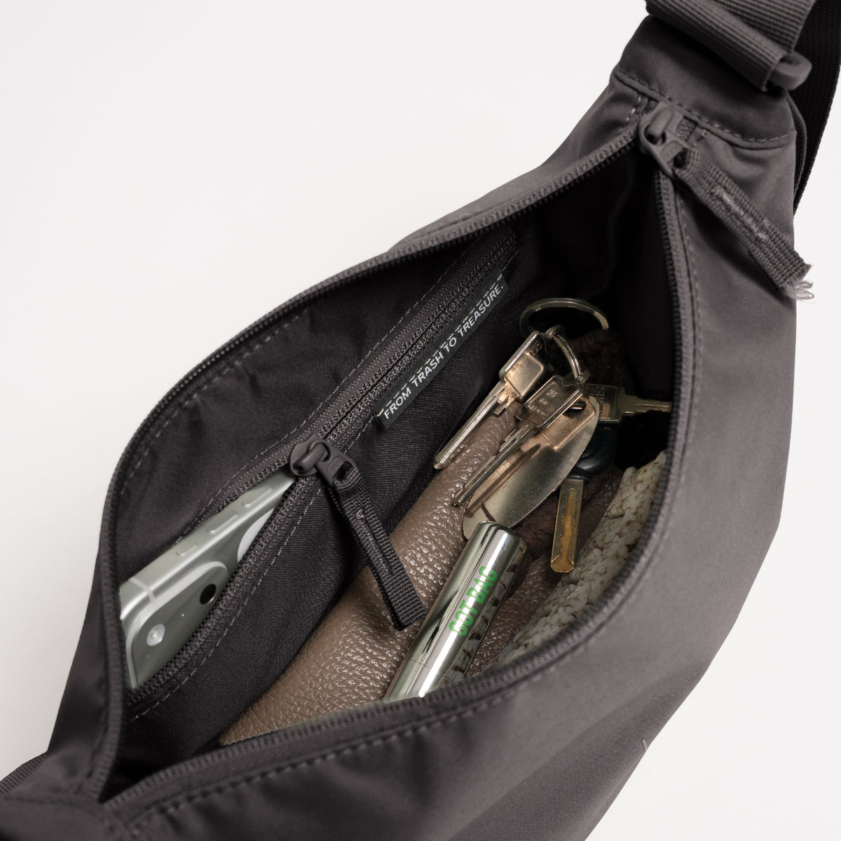 MOON BAG SMALL Tasche in mussel (dunkles Braun-Grau) Innenansicht mit Gegenständen wie Smartphone, Schlüssel und Geldbörse.