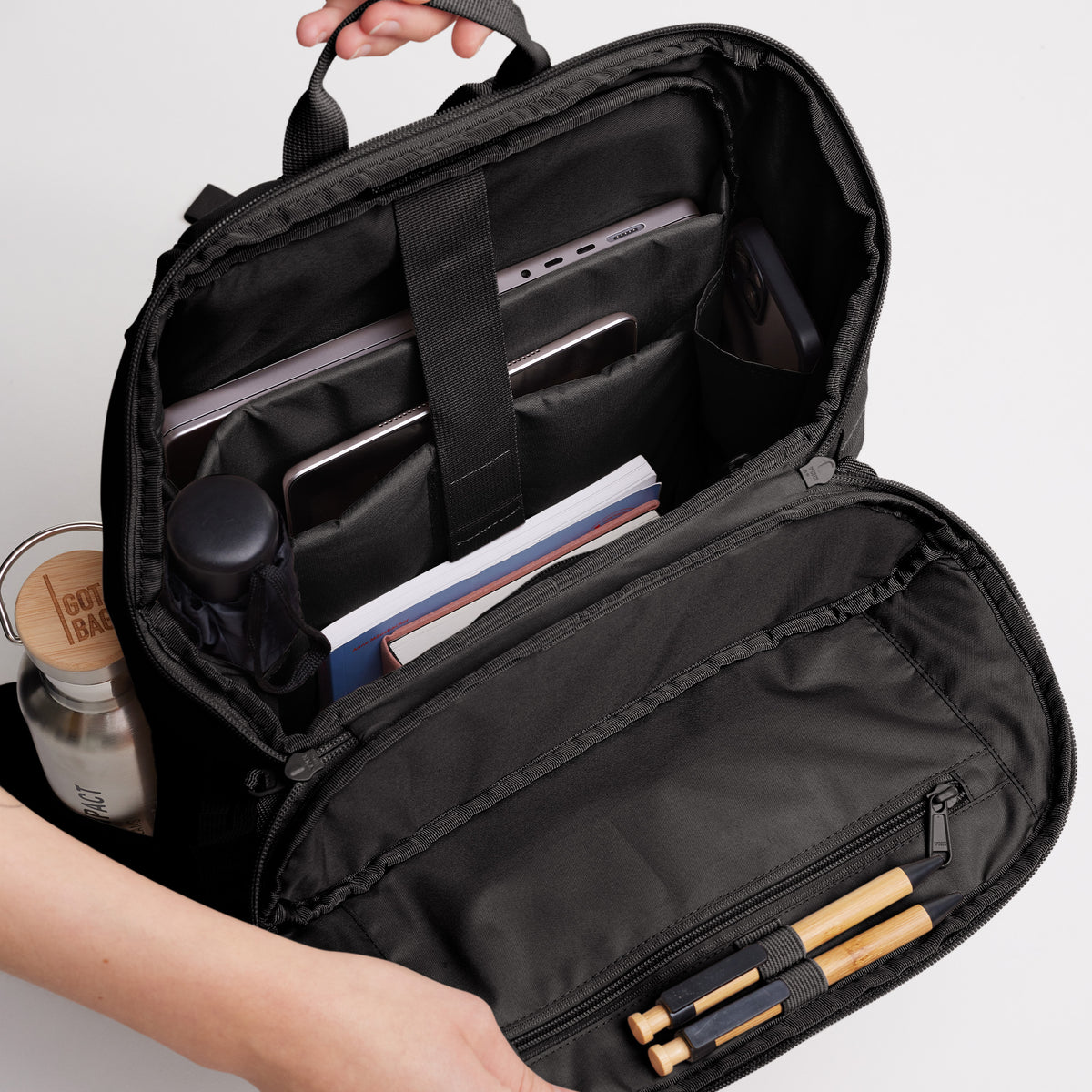 PRO PACK Rucksack in mussel (dunkles Braun-Grau) mit geöffnetem Innenfach, bestückt mit Laptop, Tablet und Stiften.