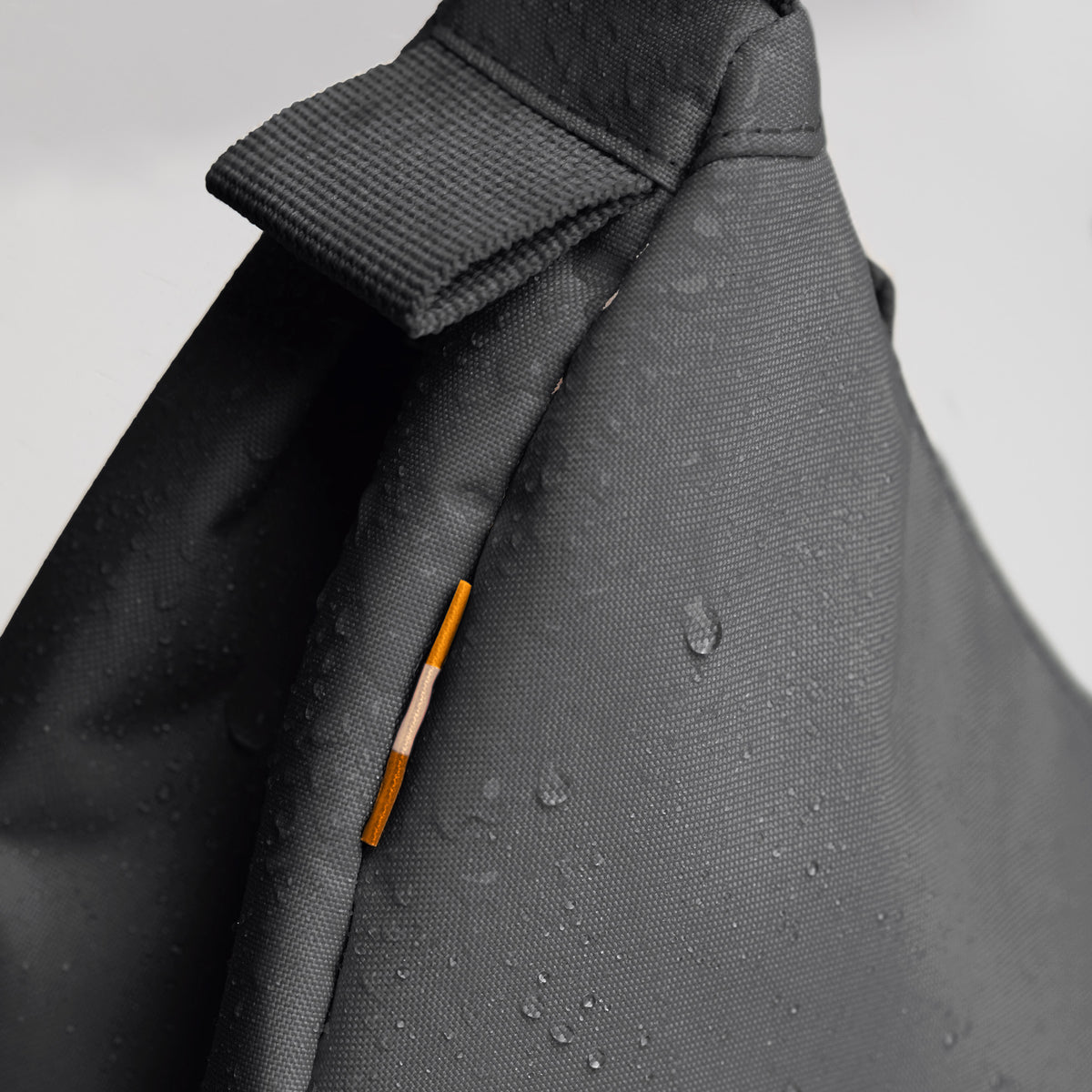 MOON BAG SMALL Tasche in shark (Dunkelgrau) als Detailaufnahme mit Wassertropfen.