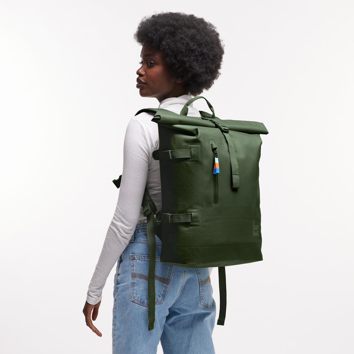 ROLLTOP Rucksack in seafloor (tiefes Dunkelgrün) von einer Frau auf dem Rücken getragen.