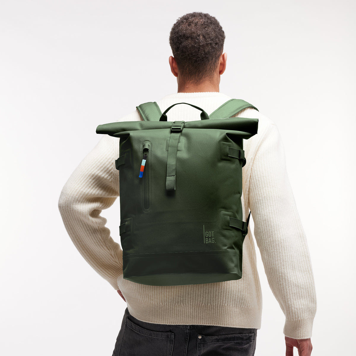 ROLLTOP Rucksack in seafloor (tiefes Dunkelgrün) von einem Mann als Rucksack auf dem Rücken getragen.