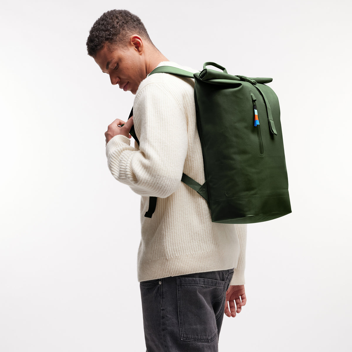 ROLLTOP LITE Rucksack in seafloor (tiefes Dunkelgrün) von einem Mann auf dem Rücken getragen.