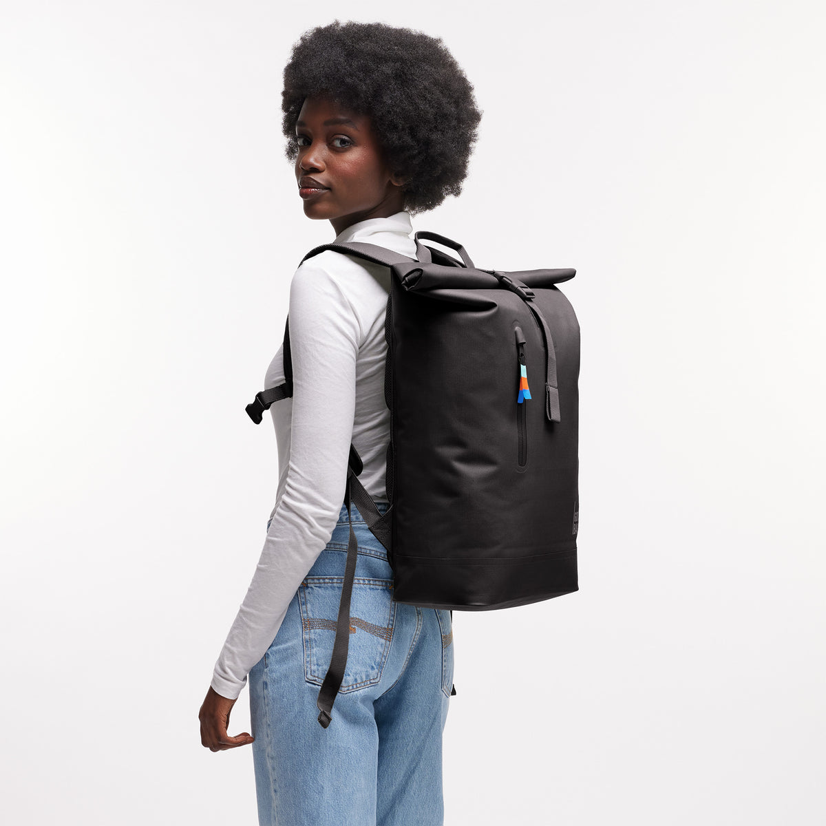 ROLLTOP LITE Rucksack in mussel (dunkles Braun-Grau) von einer Frau als Rucksack auf dem Rücken getragen.