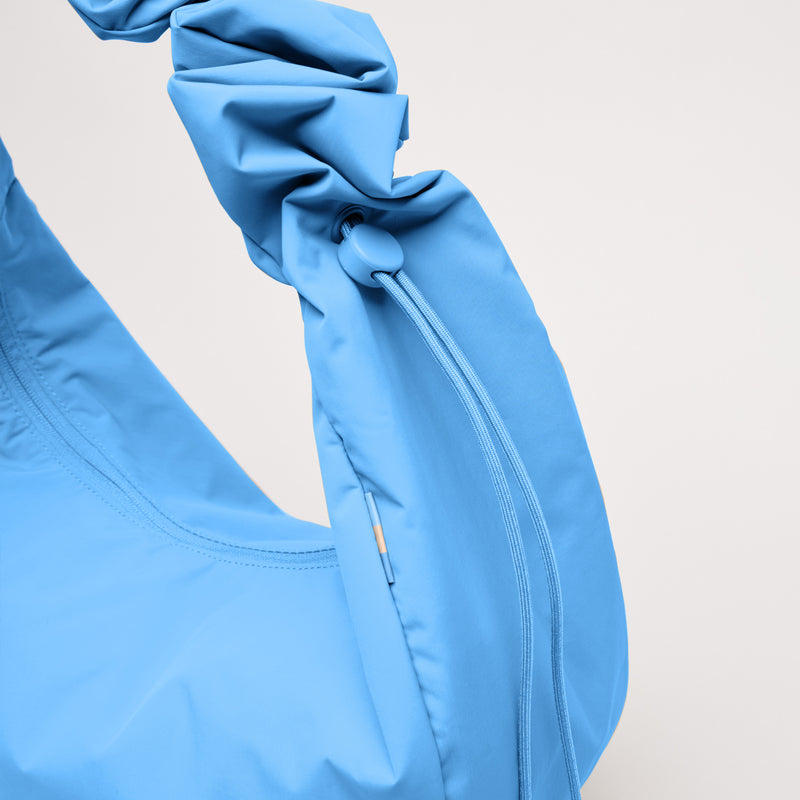 MOON BAG RUFFLE Tasche in aqua (leuchtendes Hellblau) als Detailaufnahme.