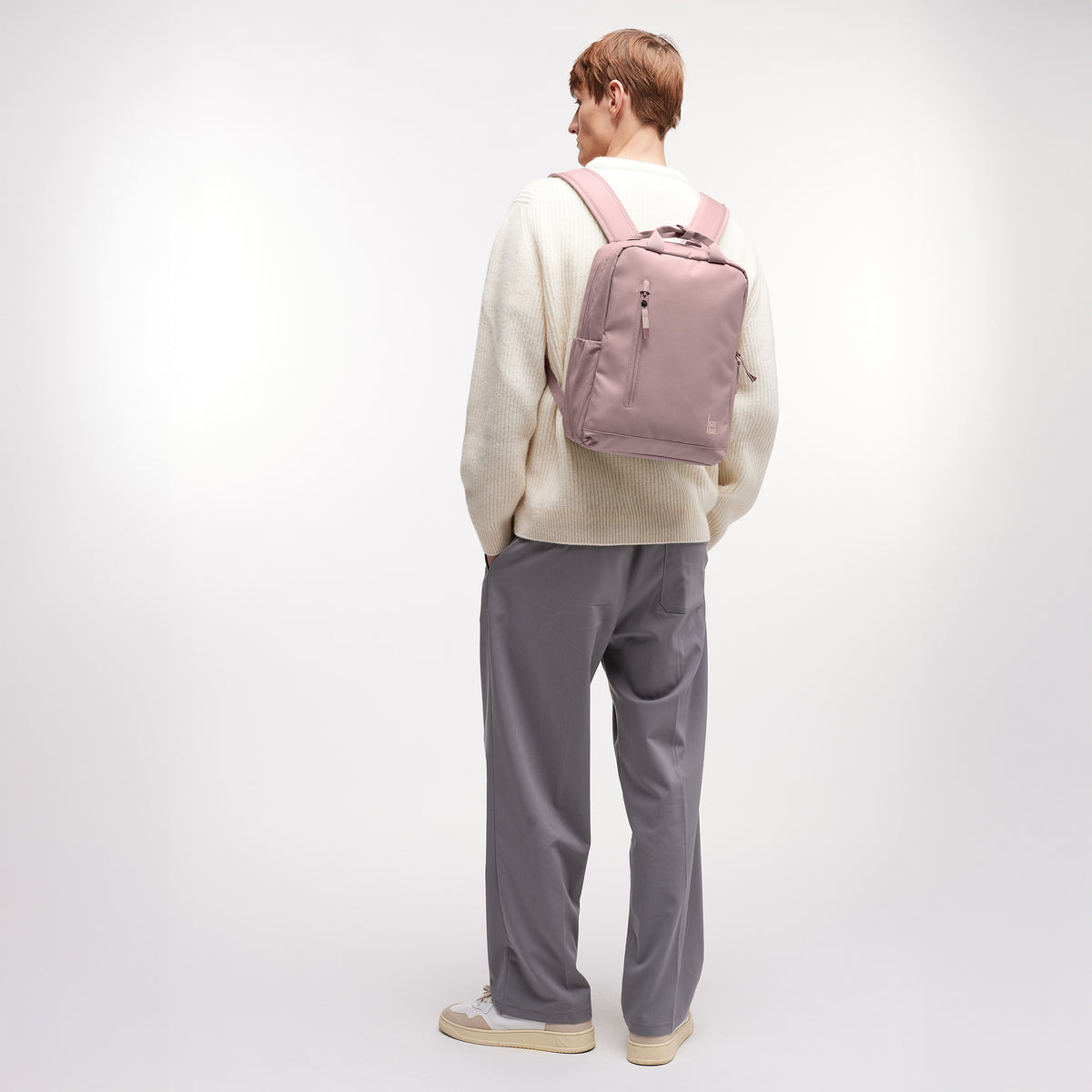 DAYPACK Rucksack in red sand (pastellfarbenes helles Rosa) von einem Mann auf dem Rücken getragen.